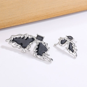 Asymmetric black butterfly stud earrings in silver finish with a molten lava aesthetic