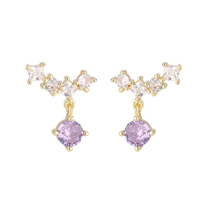 Detailed close-up of gold stud earrings with white zircons and purple round gemstones