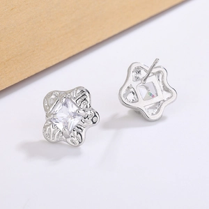 Macro detail of silver starfish stud earrings with square zircon and embossed texture