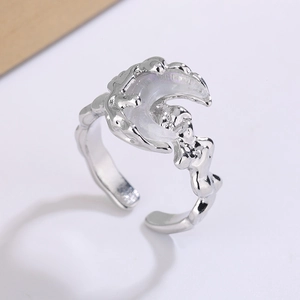Detailed macro view of silver moon ring with lava texture and iridescent white stone