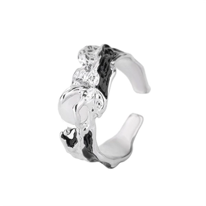 Close-up of irregular textured ring with black enamel and a white moonstone bead