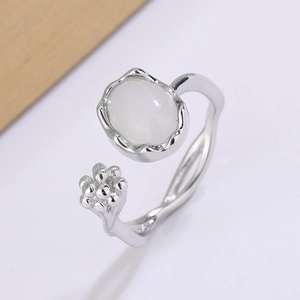 Macro shot of silver moonstone ring featuring an oval gem and delicate bead cluster floral