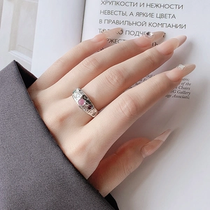 Detail of silver lava-textured ring with pink, green, and red zircon gemstones