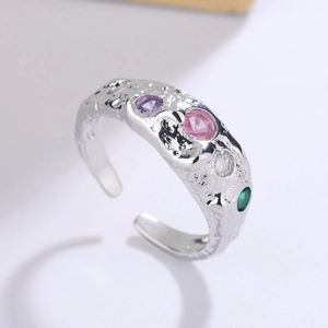 Close-up of adjustable silver ring with irregular hammered texture and colorful zircons