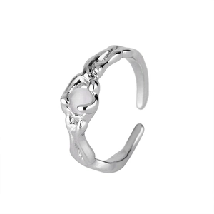 Dettaglio macro dell'anello texture lava argento con inserto tondo in opale bianco