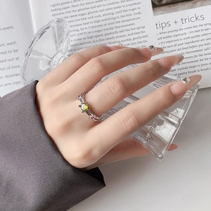 Detail view of irregular silver ring with colorful zircons on a model's finger
