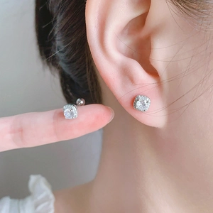 Close-up of square zircon stud earrings in silver being held by fingers to show size