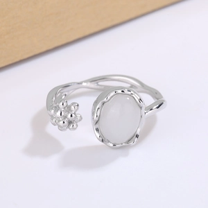 Elegant moonstone open ring with silver band and floral bead detailing in a minimalist style