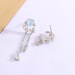 Detail of silver heart earrings with blue opal stones and sparkling crystal tassels