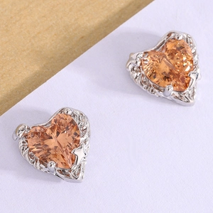 Detailed macro view of heart-shaped studs with champagne gemstones and silver finish