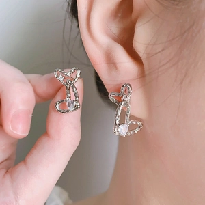 Detail of silver double heart stud earrings with hammered texture and white zircons