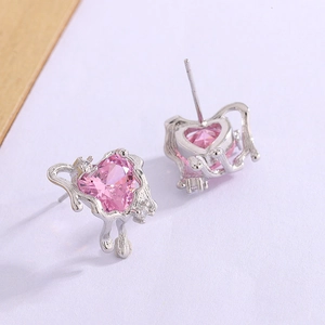Macro view of heart-shaped pink zircon earrings with irregular lava texture metal