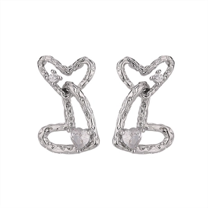 Close-up of double heart earrings with textured silver metal and clear zircon stone