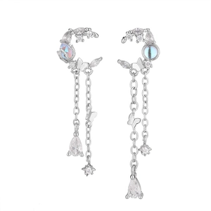 Detail of silver moon tassel earrings with butterfly star charms and blue moonstone