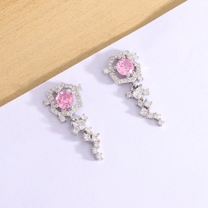 Dettaglio di orecchini con zircone rosa, cornici in argento e nappe di cristallo