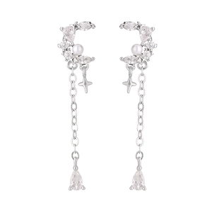 Detail of silver crescent moon earrings with long tassels and sparkling star pendants