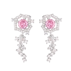 Dettaglio di orecchini a fiore con zircone rosa e nappe di cristallo scintillante
