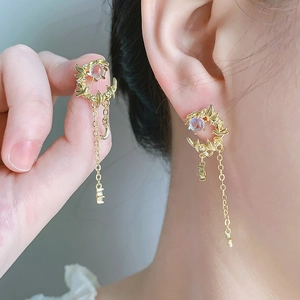 Detail of moon tassel earrings with gold crescent moon, small diamonds and moonstone beads