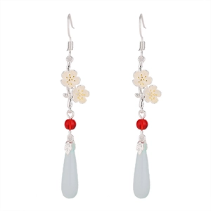 Detail of vintage earrings with pink cherry blossoms, red beads and blue teardrop pendants