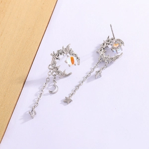 Detailed view of silver moon and star tassel earrings with glowing moonstones