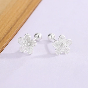 Detailed view of silver hollow flower stud earrings with secure screw ball back closures