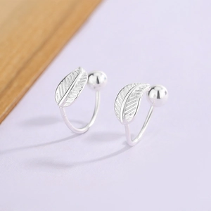 Macro view of silver feather earrings with detailed veins and polished bead closure