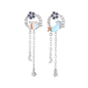 Detail of asymmetric silver floral earrings with moon stars and tassel zircon pendants