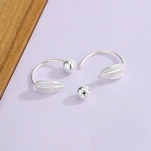 Detail of silver leaf screw back earrings showing the textured metal and ball closure