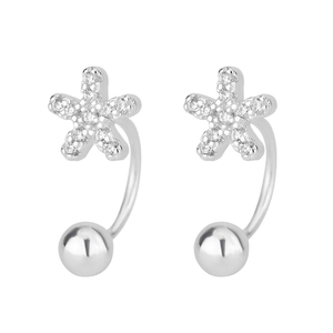 Macro shot of silver flower earrings with white zircons and a curved hook design