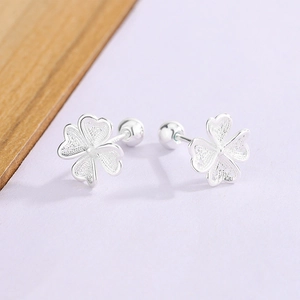 Detailed close-up of clover flower stud earrings with intricate silver filigree texture