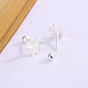 Macro shot of S925 sterling silver four-leaf clover stud earrings with screw-back detail