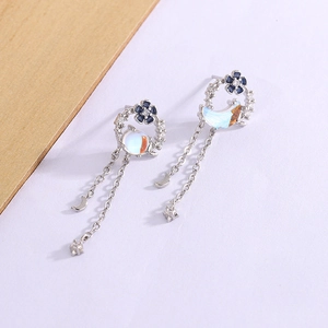 Asymmetric silver flower earrings with zircon moon and planet tassels on white wood
