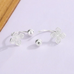 Hollow four-leaf clover S925 silver stud earrings with screw back on purple background
