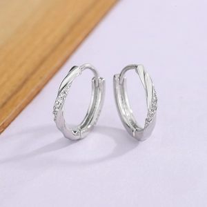 Silver twist hoop earrings with sparkling micro-pave zirconia on a soft purple backdrop