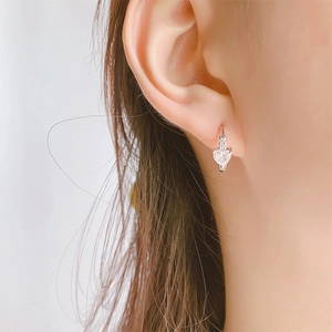Gros plan de boucles d'oreilles pendantes en forme de cœur avec zircon argenté