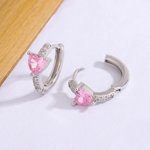 Détail de boucles d'oreilles cœur en zircon rose avec petits diamants et argent