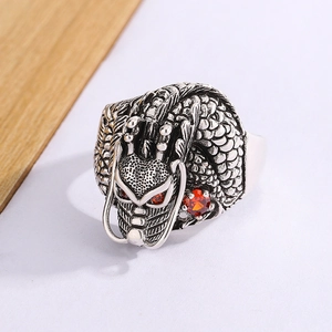 Detailed macro view of vintage silver dragon ring featuring striking red ruby eyes