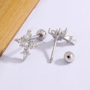 Elegant silver rhombic cross stud earrings with sparkling cubic zirconia on wood