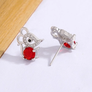 Macro shot of mouse earrings featuring red gemstones and sparkling white zircons