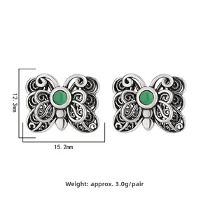 Detailed view of butterfly stud earrings with green agate and filigree metal wings