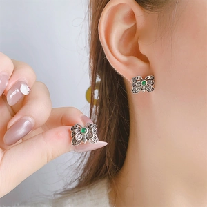 Detailed view of vintage butterfly stud earring featuring green agate and filigree