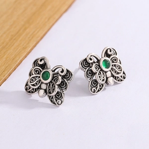 Detail of vintage silver butterfly stud earrings with green agate and hollow carvings