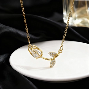 Macro detail of tulip necklace with teardrop crystal pendant on black satin background