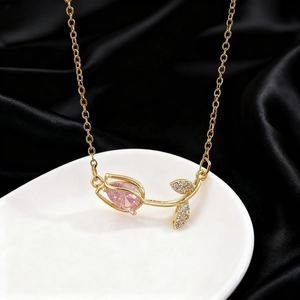 Detail of tulip necklace with pink water drop gemstone and pavé leaf on black silk