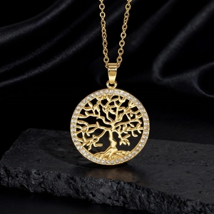 Dettaglio di un ciondolo Albero della Vita dorato con cristalli luminosi e design traforato