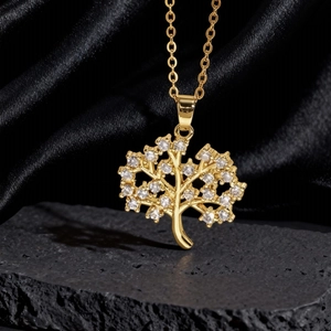 Dettaglio della collana con ciondolo albero della vita dorato e zirconi su pietra