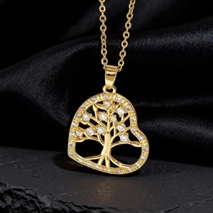 Macro di una collana a cuore dorata con pendente Albero della Vita e cristalli lucidi