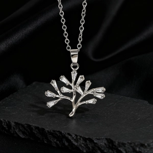 Macro del ciondolo albero della vita in argento con zirconi su una superficie di pietra