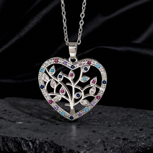 Dettaglio della collana albero della vita a cuore con gemme colorate su seta nera