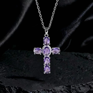 Dettaglio della collana a croce argento con cristalli viola su seta nera e roccia